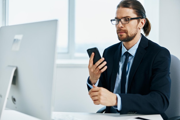 Büroangestellter sitzt an einem Schreibtisch vor einem Computer Lifestyle Hochwertiges Foto