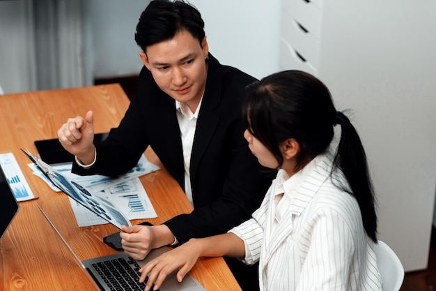 Büroangestellter und Manager analysieren Finanzberichtspapier am harmonischen Arbeitsplatz