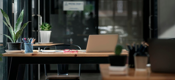 Foto büroarbeitsplatz in dunklem ton. schreibtisch aus holz mit laptop und dokumenten, modernes interieur mit gemütlichem schrank, komfortabler arbeitsplatz, arbeitsplatz mit computer zu hause.