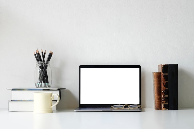 Foto büroarbeitsplatzmodell-laptop, bücher, bleistift und kaffeetasse auf schreibtisch.