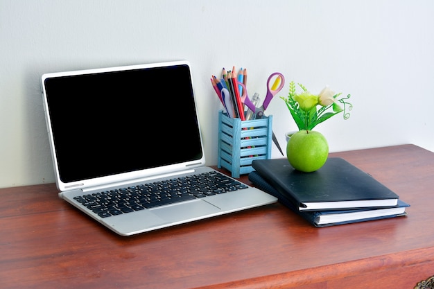 Bürobedarf, Laptop mit Notebook und Apfel auf Holztisch