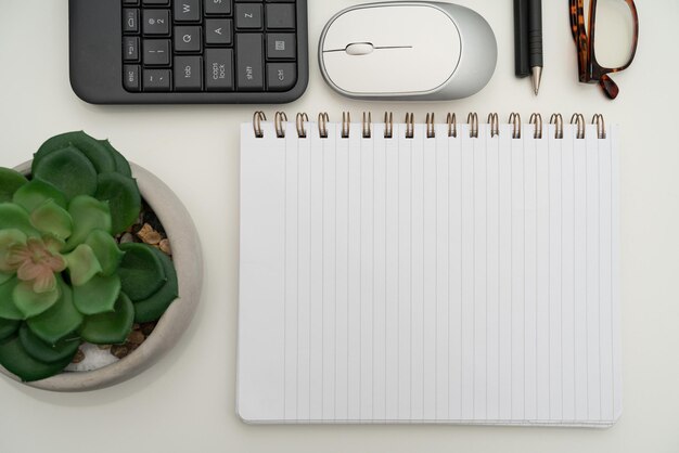 Bürobedarf über Schreibtisch mit Tastatur und Brille und Kaffeetasse zum Arbeiten aus der Ferne sortiert