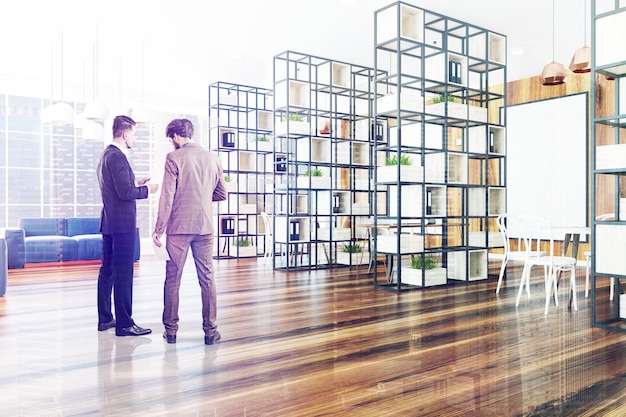 Büroecke aus Holzwand mit dunklem Holzboden, schwarzem Bücherregal und blauem Sofa in der Ecke. Ein gerahmtes Poster an der Wand. Geschäftsleute 3D-Rendering-Attrappe mit getöntem Bild und Doppelbelichtung