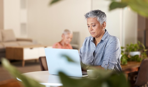 Bürokaffee und reife Frau mit Laptop-Eingabeidee für kreatives Startup-Unternehmen oder Bericht am Schreibtisch Leitender freiberuflicher Designer oder Schriftsteller, der im modernen Büro an Ideen denkt und arbeitet