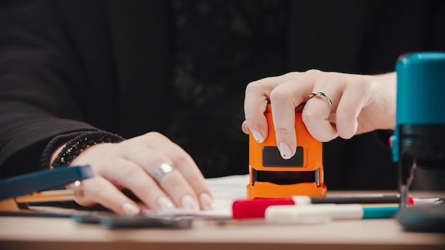 Bürokonzept, das das Dokument mit einem orangefarbenen Stempel stempelt