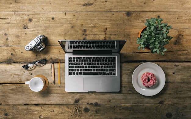 Büromaterial mit Fotokamera-Laptop und Draufsicht der Kaffeetassen-Donut-Pflanze mit Exemplar für Ihren individuellen Text