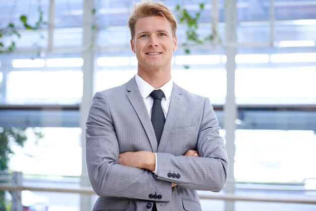 Büroporträt und Geschäftsmann mit gekreuzten Armen für glücklich im Job Lächeln und professioneller Arbeiter am Arbeitsplatz Buchhalter positiv und Gesicht mit Mission in Unternehmens- und formalen Anzug für die Arbeit