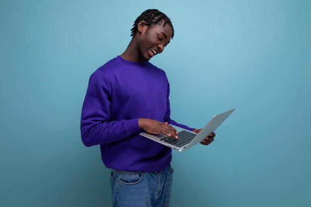 Bürospezialist afrikanischer junger brünette Mann mit Dreadlocks mit Laptop