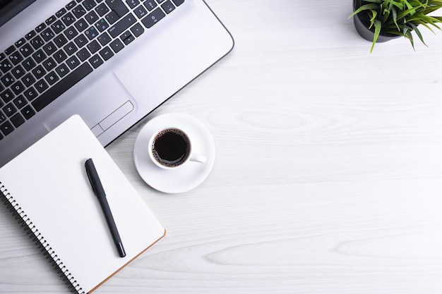 Foto bürotisch mit laptop, smartphone, tasse kaffee und zubehör, auf hölzernem hintergrund. draufsicht mit kopierraum, flach liegen.