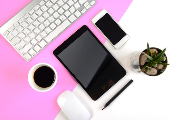 Bürotisch mit Tastatur, Maus, digitaler Tablette und Smartphone auf Hintergrund mit zwei Tönen.