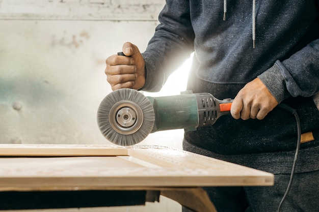 Foto bürsten von holz mit einem elektrischen rotationsbürstenschleifer