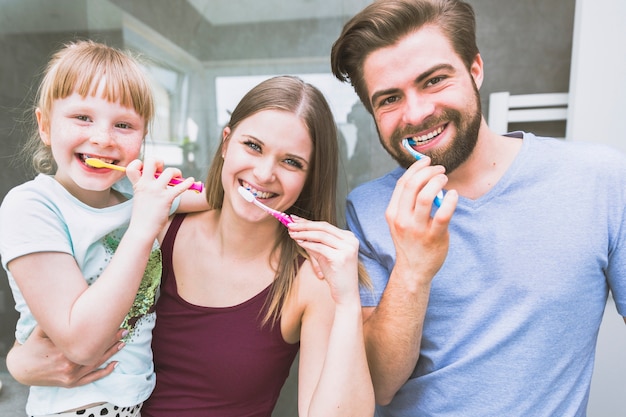 Foto bürstende zähne der schönen familie für kamera