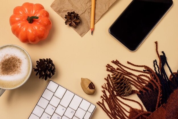 Bufanda cálida Taza de café Cuaderno o teclado Calabaza Cono de pino Acogedor fondo de otoño