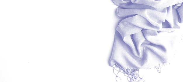 Bufanda sobre un fondo blanco. Color 2022, muy peri, textura de tela para diseño. Bufanda de mujer abstracta azul violeta claro. Vista superior