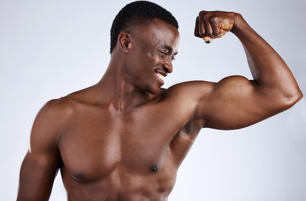 Buff y me encanta. Captura recortada de un apuesto joven musculoso flexionándose en el estudio contra un fondo gris.