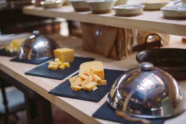 Buffet. El camarero sostiene un plato de queso en lonchas.