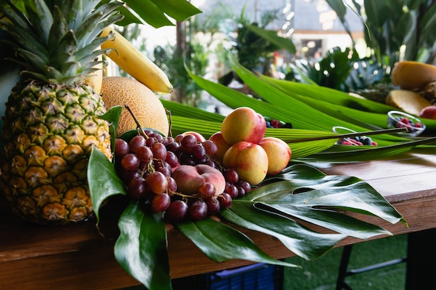 Buffet de hotel de frutas decorado con hojas verdes