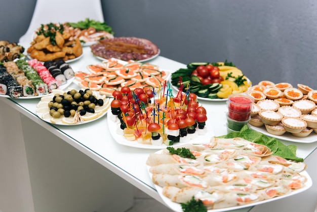 El buffet en la recepción Surtido de canapés Servicio de banquetes catering comida snacks con queso jamon prosciutto y fruta