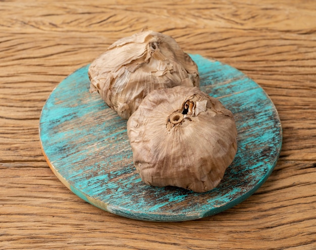 Bulbos de ajo negro fermentado sobre mesa de madera