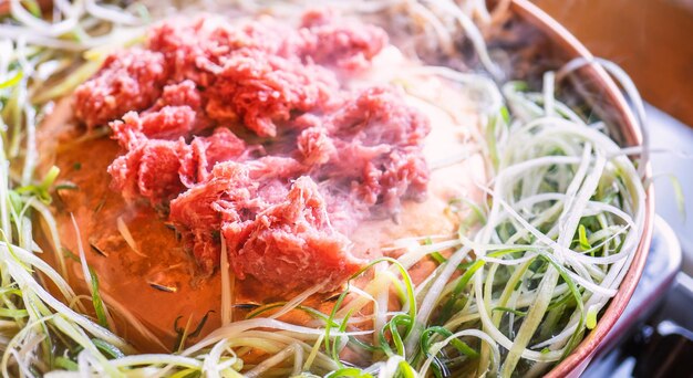Bulgogi de barbacoa de ternera en el restaurante de Corea del Sur en el estilo de vida de Seúl cocina de comida coreana fresca en una sartén de cobre con una parrilla en rodajas cerca del espacio de copia