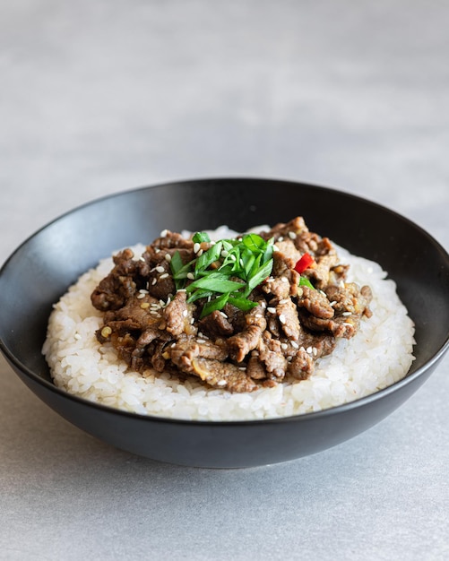 Bulgogi com arroz em um fundo de concreto prato de carne tradicional coreano comida asiática foco seletivo