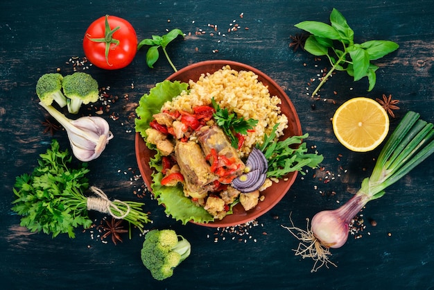 Bulgur con carne pimentón tomates cherry y verduras Sobre un fondo de madera Vista superior Espacio de copia