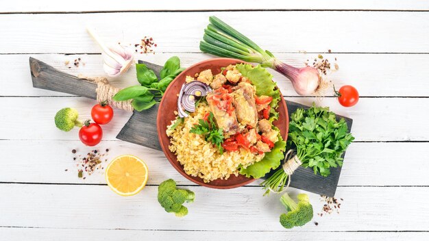 Bulgur con carne pimentón tomates cherry y verduras Sobre un fondo de madera Vista superior Espacio de copia