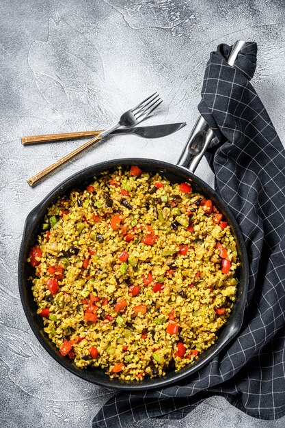 Bulgur cocido con verduras y carne de pollo en una sartén. Vista superior