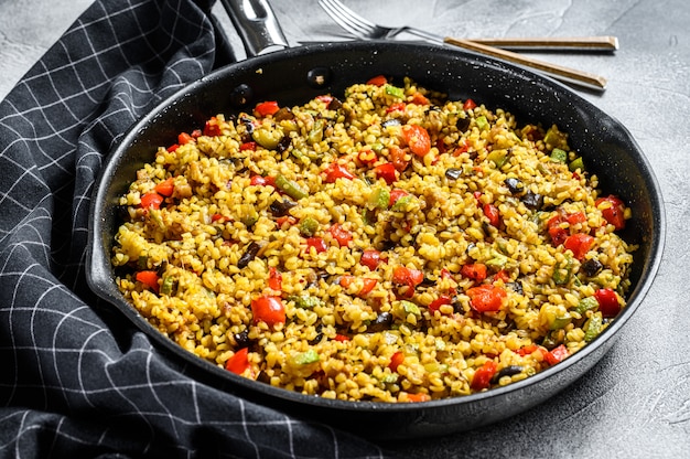 Bulgur cocido con verduras en una sartén.