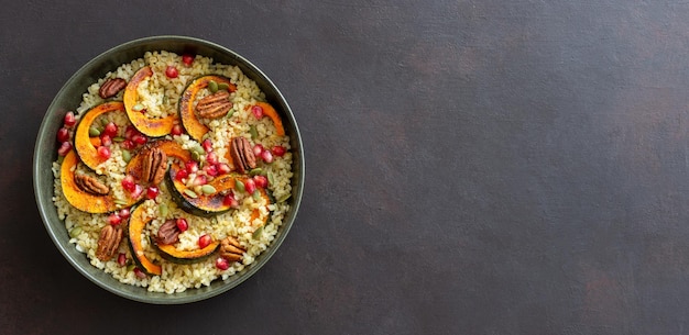 Bulgur com abóbora, romã e noz pecã. Alimentação saudável. Comida vegetariana.