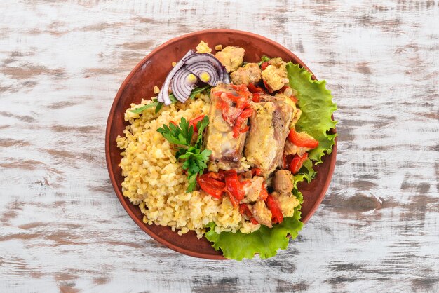 Bulgur com carne páprica, tomate cereja e legumes Em um fundo de madeira Vista superior Copiar espaço