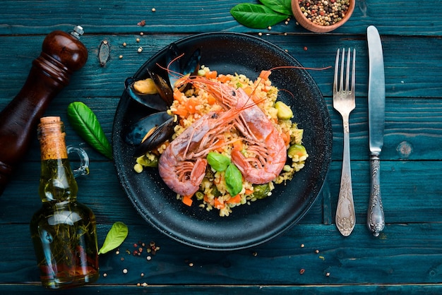 Bulgur mit Garnelen, Muscheln und Gemüse Auf dem alten Hintergrund Draufsicht Freier Platz für Ihren Text