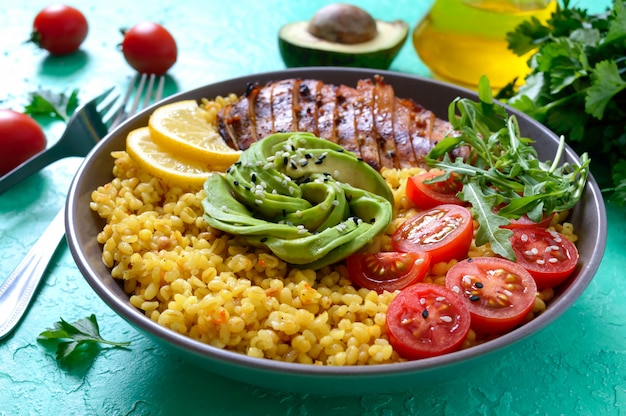 Bulgur mit gegrilltem Hähnchenfilet, frischem Gemüse, Avocado, Gemüse. Diät-Mittagessen. Gesundes Essen