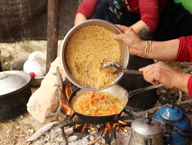 Bulgur-Pilaw gekocht im Holzfeuer Nomadische türkische Frauen