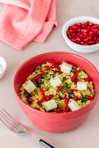 Bulgur con queso, pimiento, berenjena y granada.