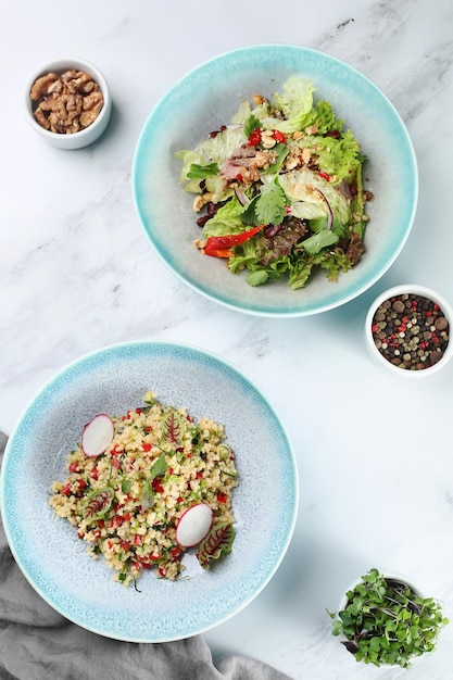 Bulgur con verduras y ensalada con verduras frescas y carne en la vista superior de fondo claro. Vista superior de la mesa de la cena con ingredientes en la mesa.