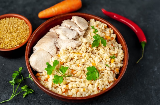 Bulgur con verduras y filete de pollo en un tazón