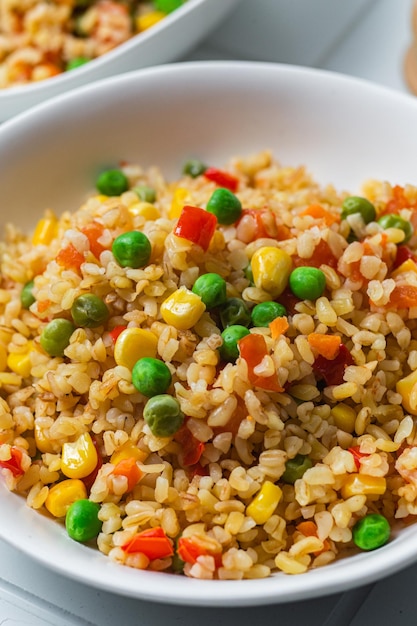 Bulgur con verduras en un plato blanco de cerca