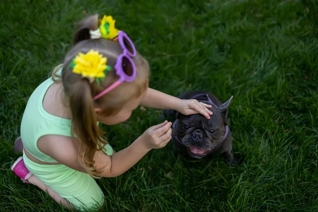 Bulldog francés mira a una niña que le da comida