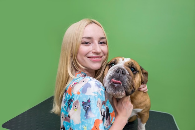 bulldog inglês e mulher estão felizes Bulldog inglês e tosador em um salão de cachorro Foto de retrato