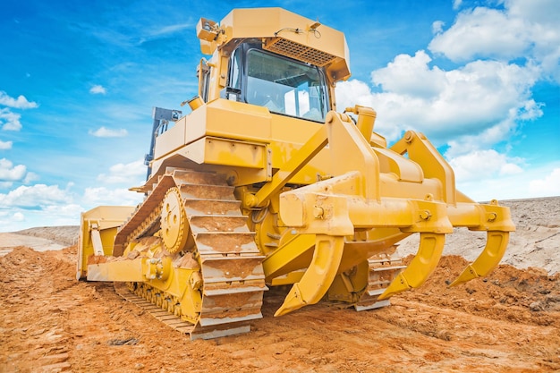 Bulldozer amarelo em pé na vista traseira de areia