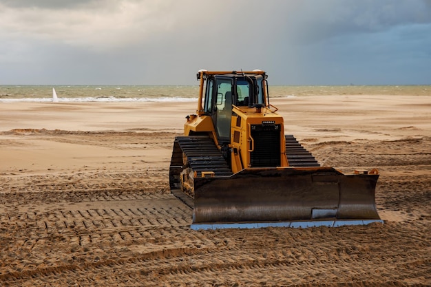 Bulldozer bereitet den Meeresstrand für die Saison vor