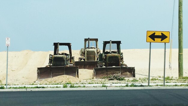 Foto bulldozer estacionado en la playa contra un cielo despejado