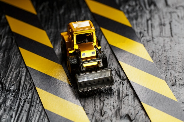 Foto bulldozer de juguete amarillo. cinta de cerca negra y amarilla