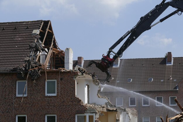 Foto bulldozer zerstört ein haus gegen den himmel