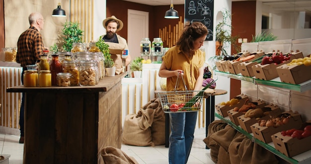 Bullicioso supermercado sin desperdicio, lleno de clientes deambulando por los pasillos en busca de alimentos orgánicos básicos para su despensa. Tienda local de barrio donde los clientes compran frutas, verduras, cereales, especias y pastas.