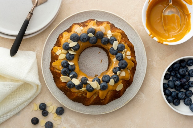 Bundt cake con glaseado de mantequilla de maní. Pastel de azúcar saludable sin gluten con semillas de chía decorado con arándanos y hojuelas de almendra.