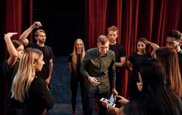 Übung im Gange Gruppe von Schauspielern in dunkler Kleidung bei der Probe im Theater