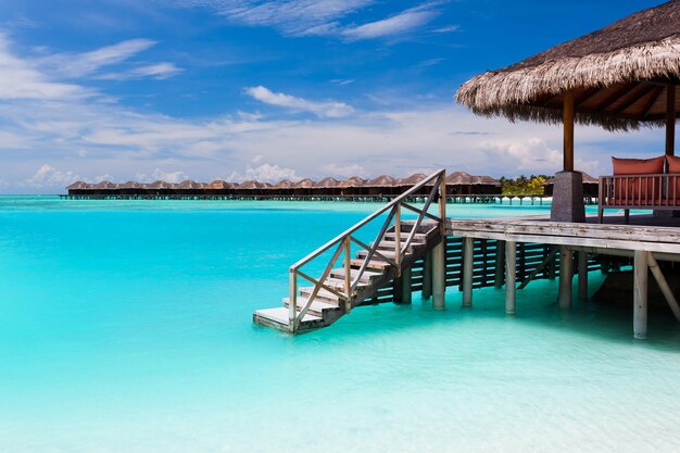 Bungalow über dem Wasser mit Stufen in die blaue Lagune