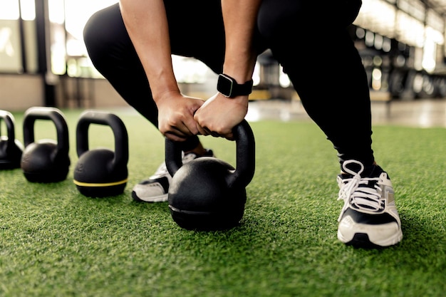 Übungskonzept Die schwarzen Kettlebells werden auf dem grünen Teppich ausgekleidet, um Kettlebell zu machen